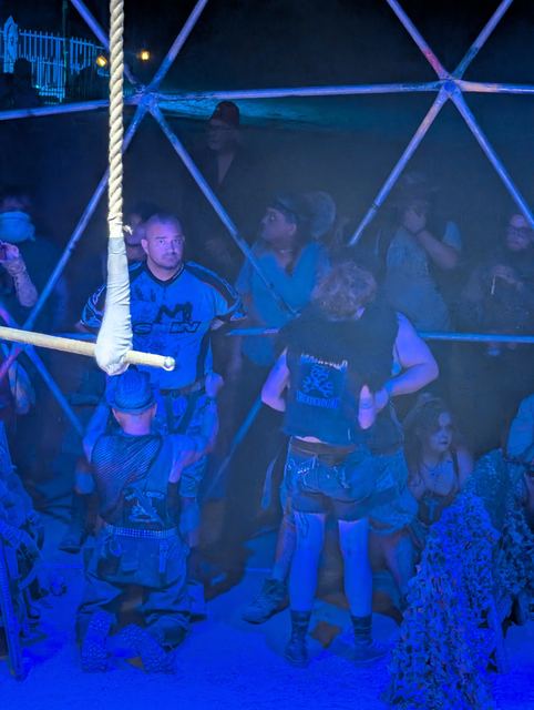 The Thunderdome crowd presses against the dome bars as fighters size each other up.