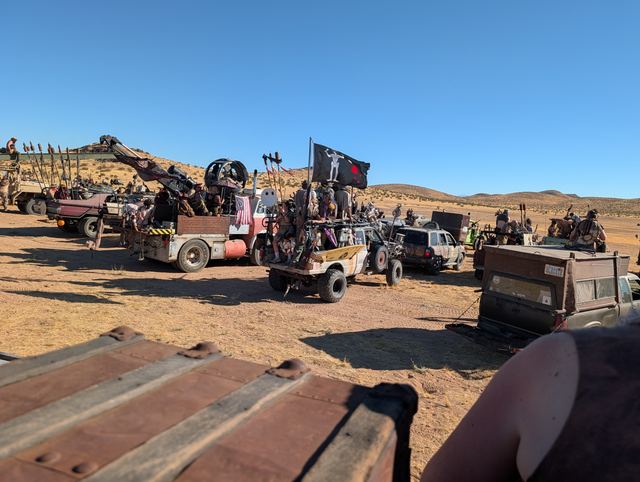 The convoy ready to move, black flags snapping above the trucks.