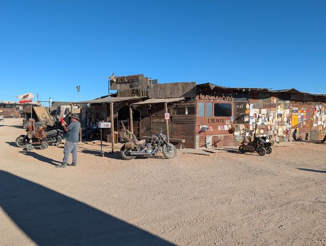 A rustic bar shack with motorcycles parked out front.