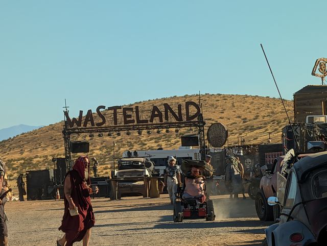 A wastelander in red robes near the Wasteland gate on the hill.