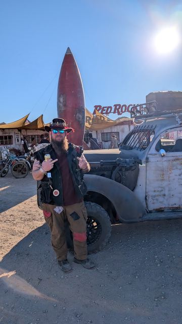 Grandpa poses in front of the war car and the Red Rocket.